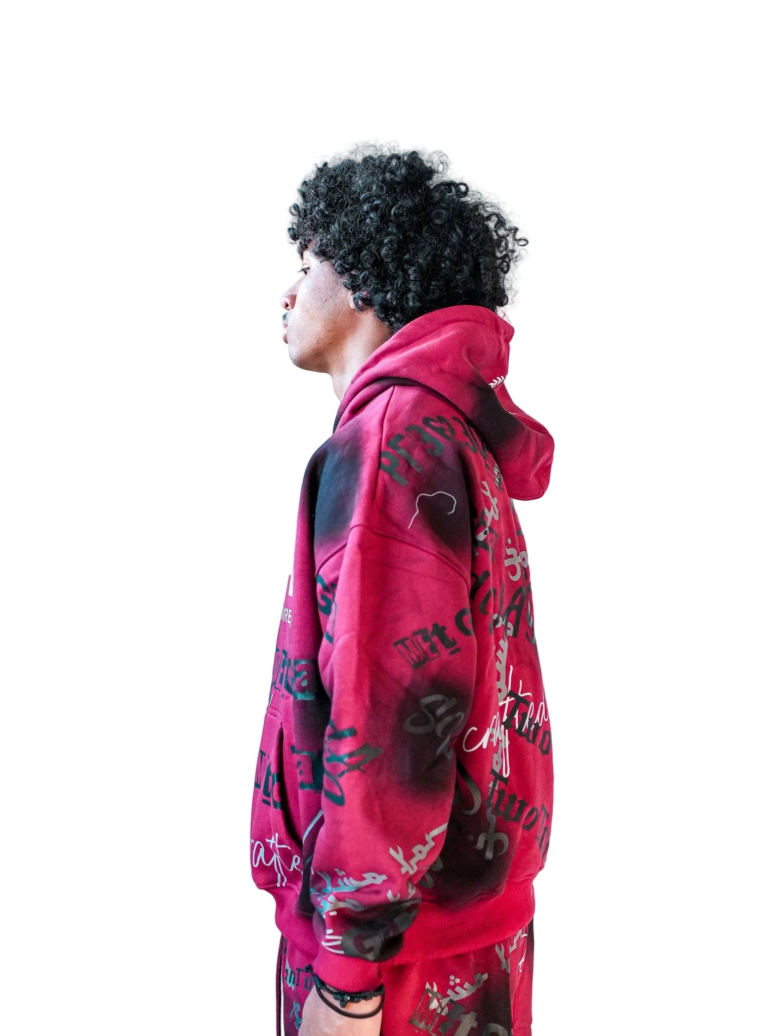 Person wearing a red hoodie with black designs against a plain background